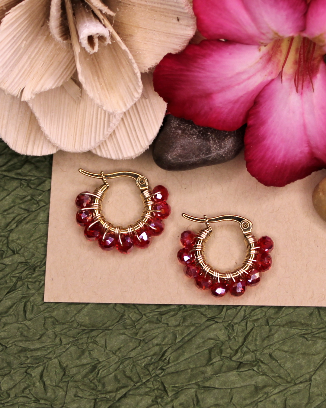 Mini stainless steel gold hoop earrings with transparent red crystal beads. 