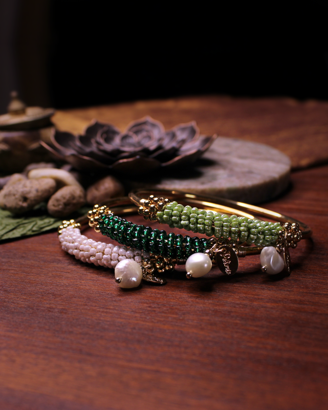 Gold colored bangle bracelet, set of three with wired gold and dark green, light green, bone white crystal beads and freshwater pearl dangling bead. 