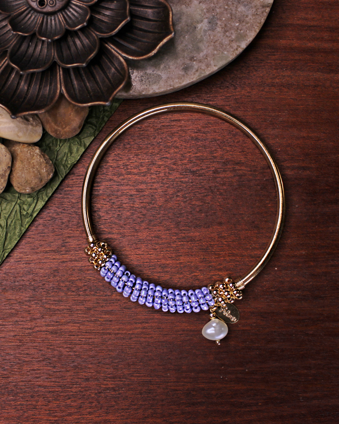 Gold colored bangle bracelet with wired gold and cerulean blue crystal beads and freshwater pearl dangling bead.