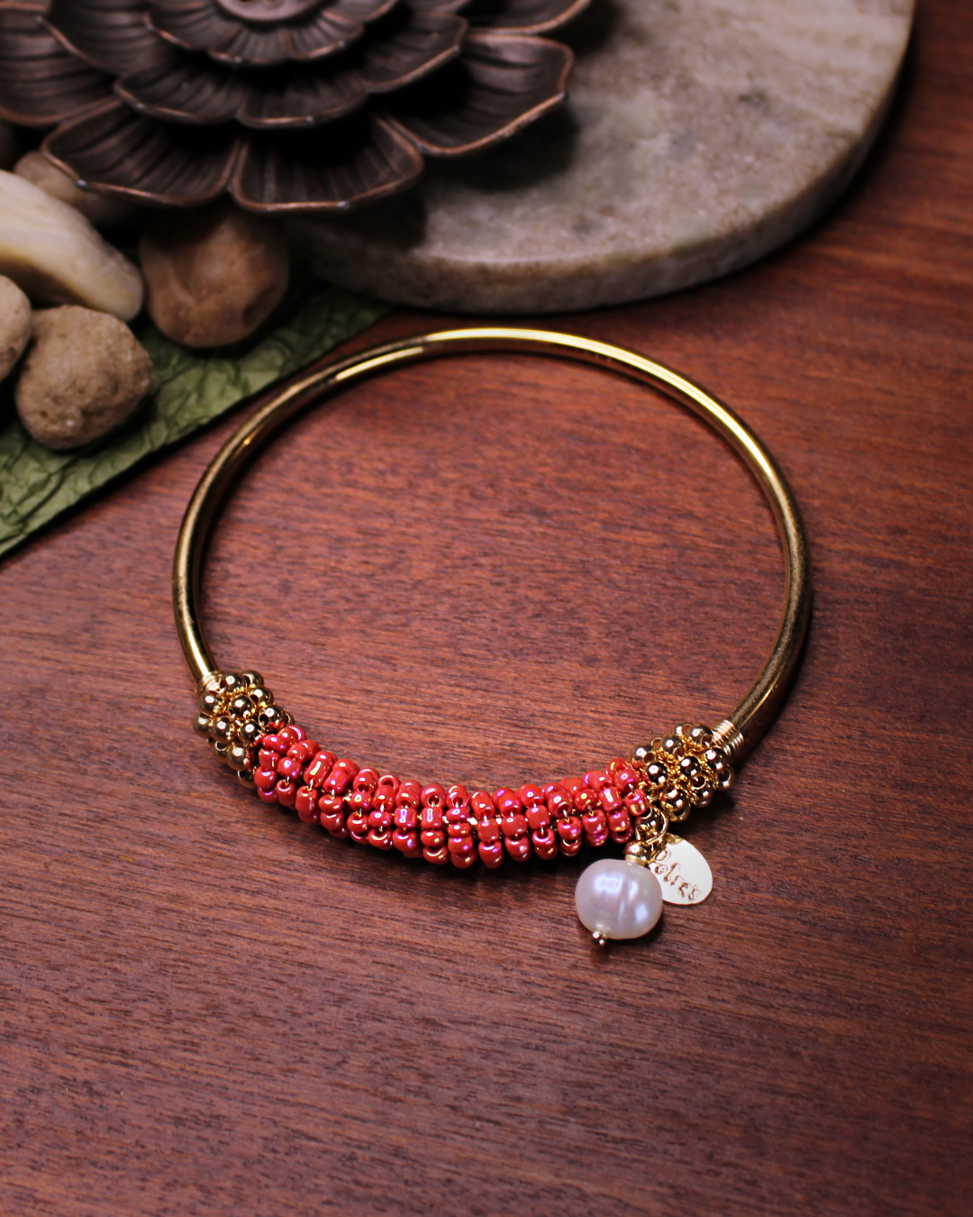 Gold colored bangle bracelet with wired gold and salmon colored crystal beads and freshwater pearl dangling bead.