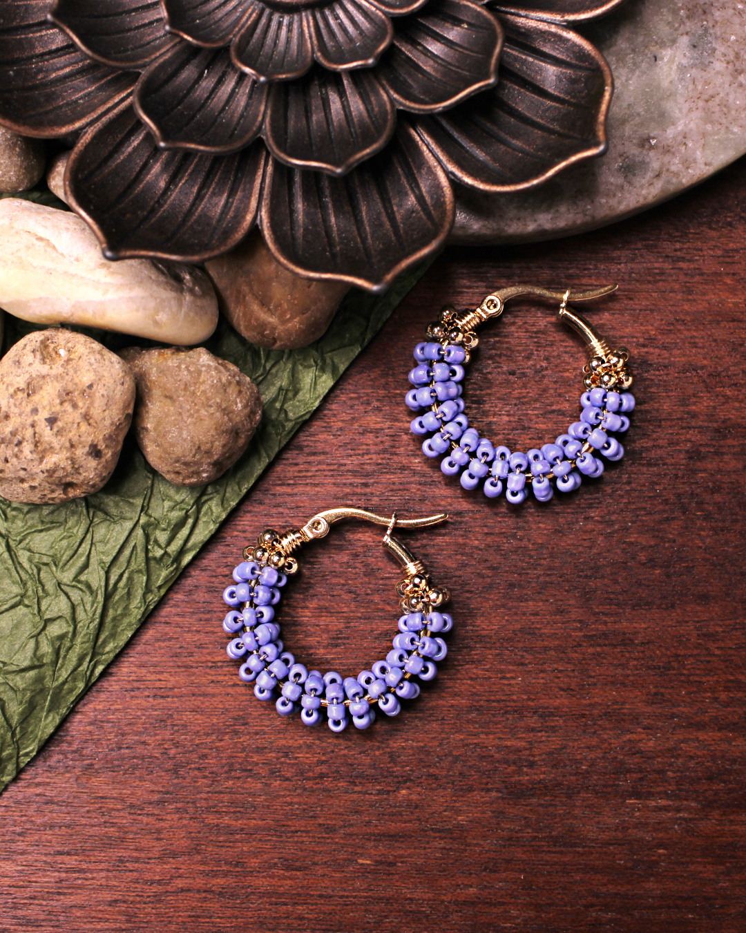 Small stainless steel gold colored hoop earrings with cerulean crystal seed beads.