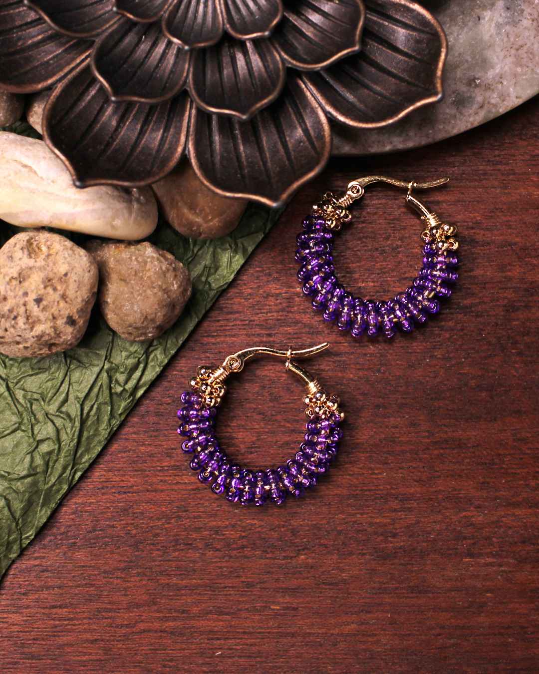 Small stainless steel gold colored hoop earrings with  dark purple crystal seed beads.