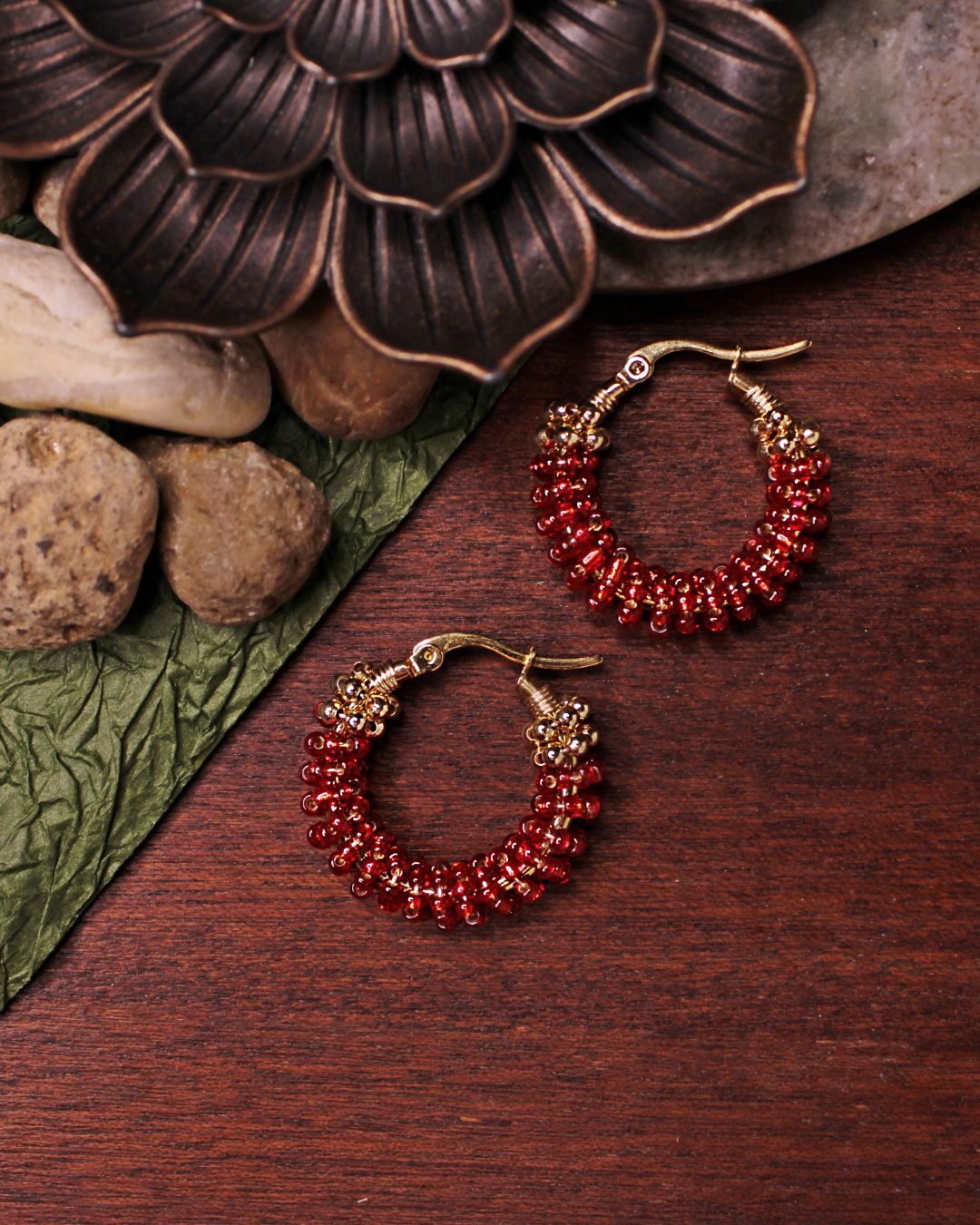 Small stainless steel gold colored hoop earrings with red crystal seed beads.