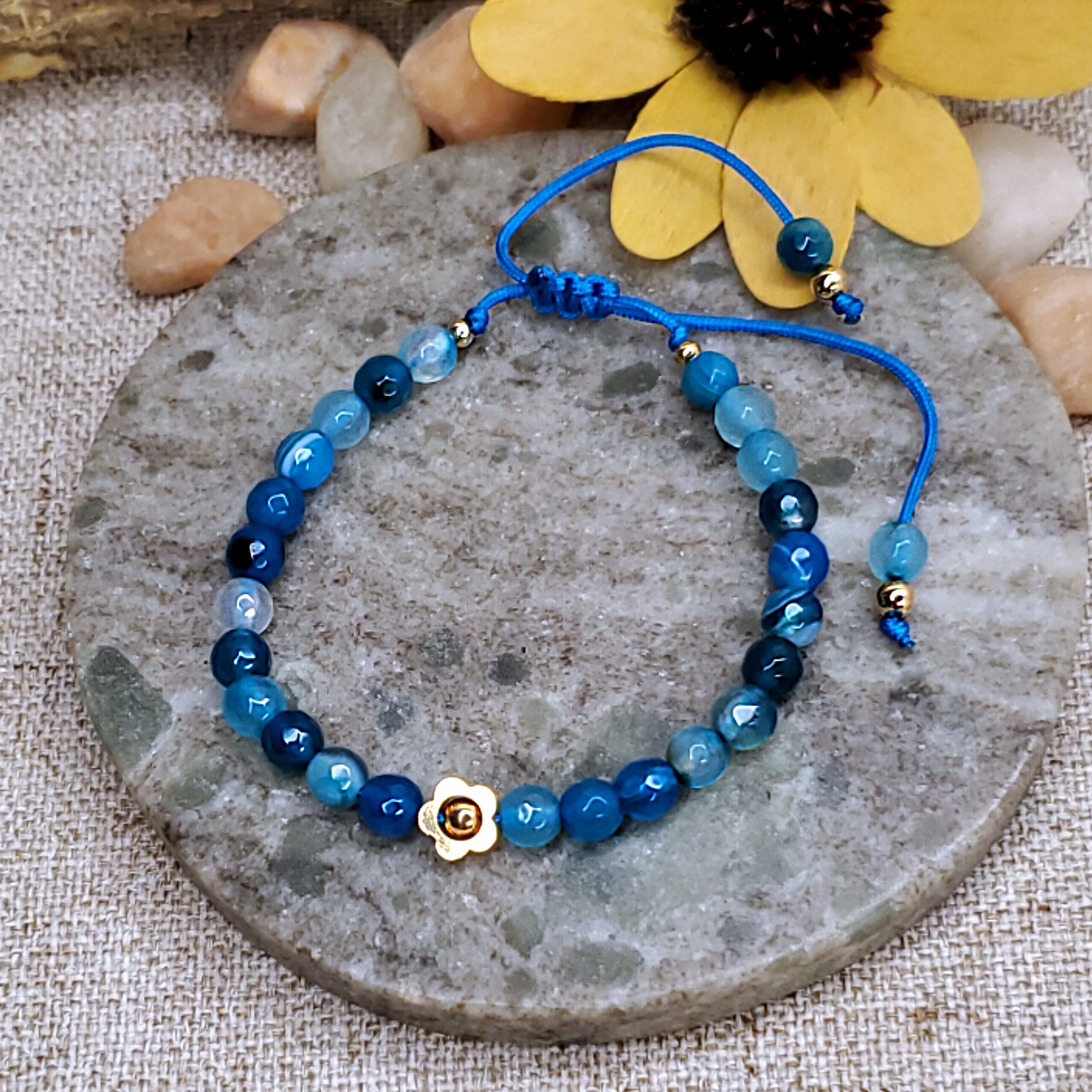 Blue faceted bead bracelet with gold flower bead.