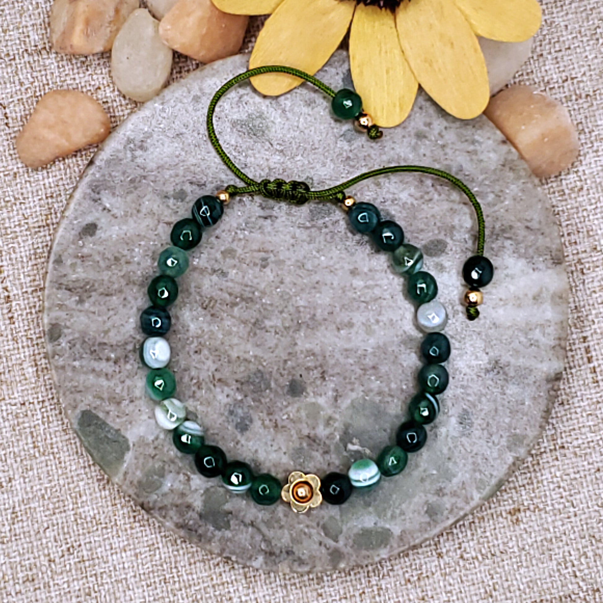 Green faceted bead bracelet with gold flower bead.