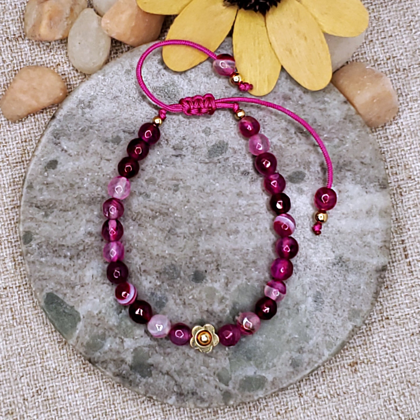 Pink faceted bead bracelet with gold flower bead.