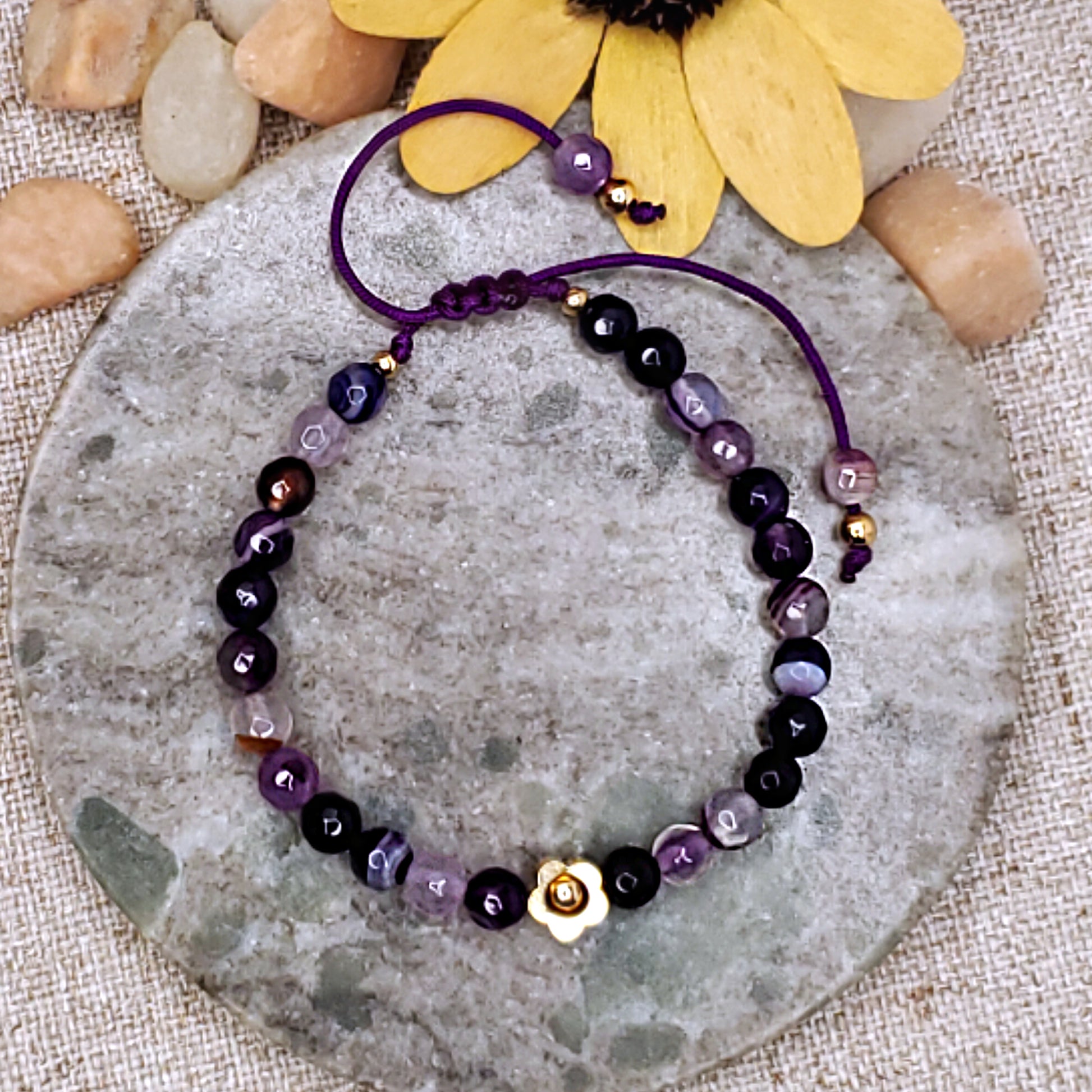 Purple faceted bead bracelet with gold flower bead.