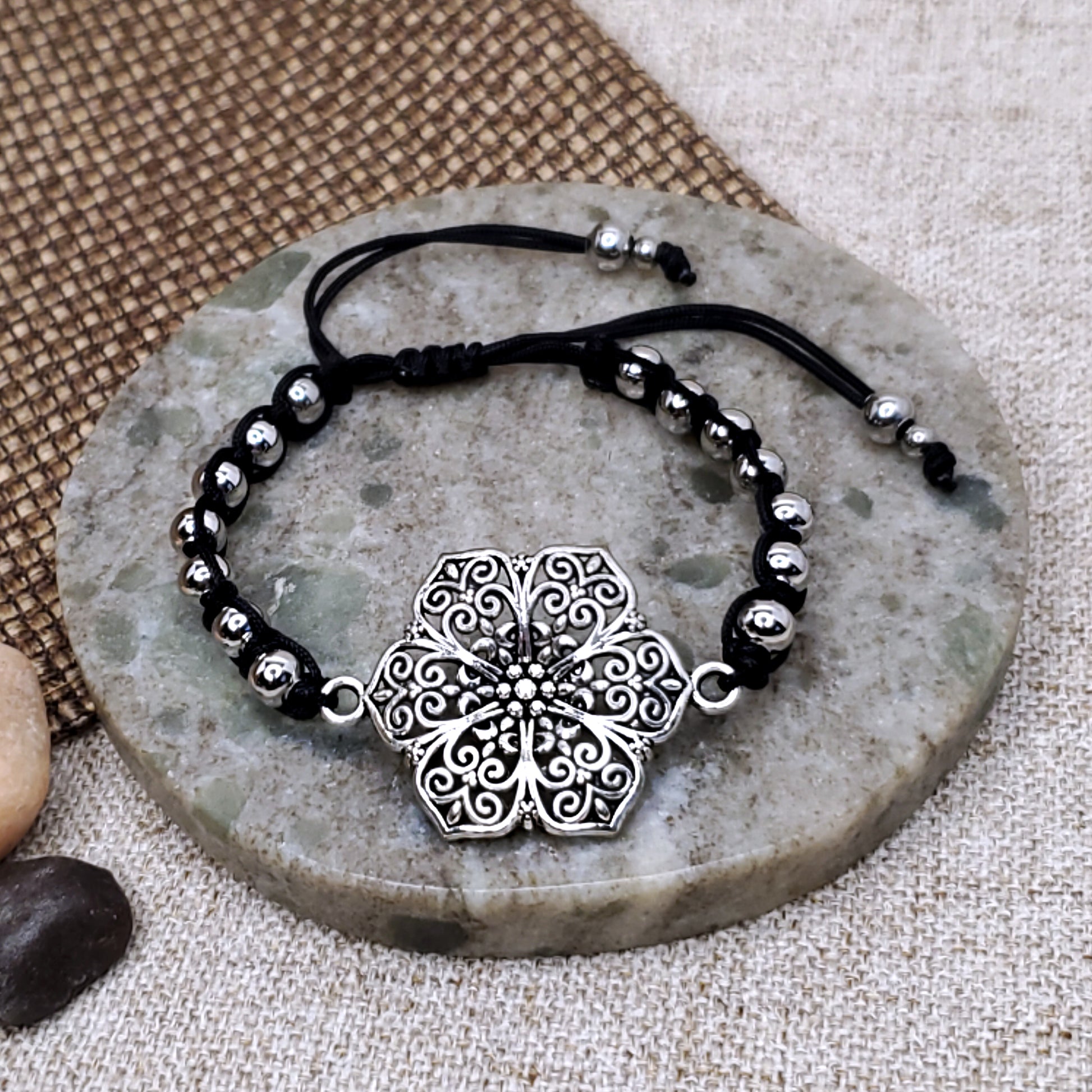 Silver flower adjustable black bracelet.