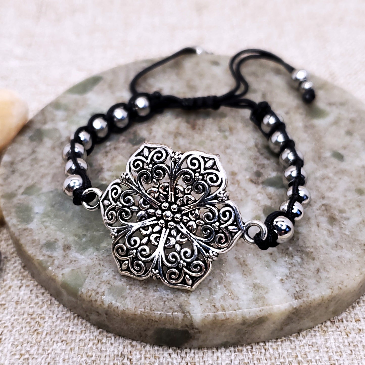 Silver flower adjustable black bracelet.