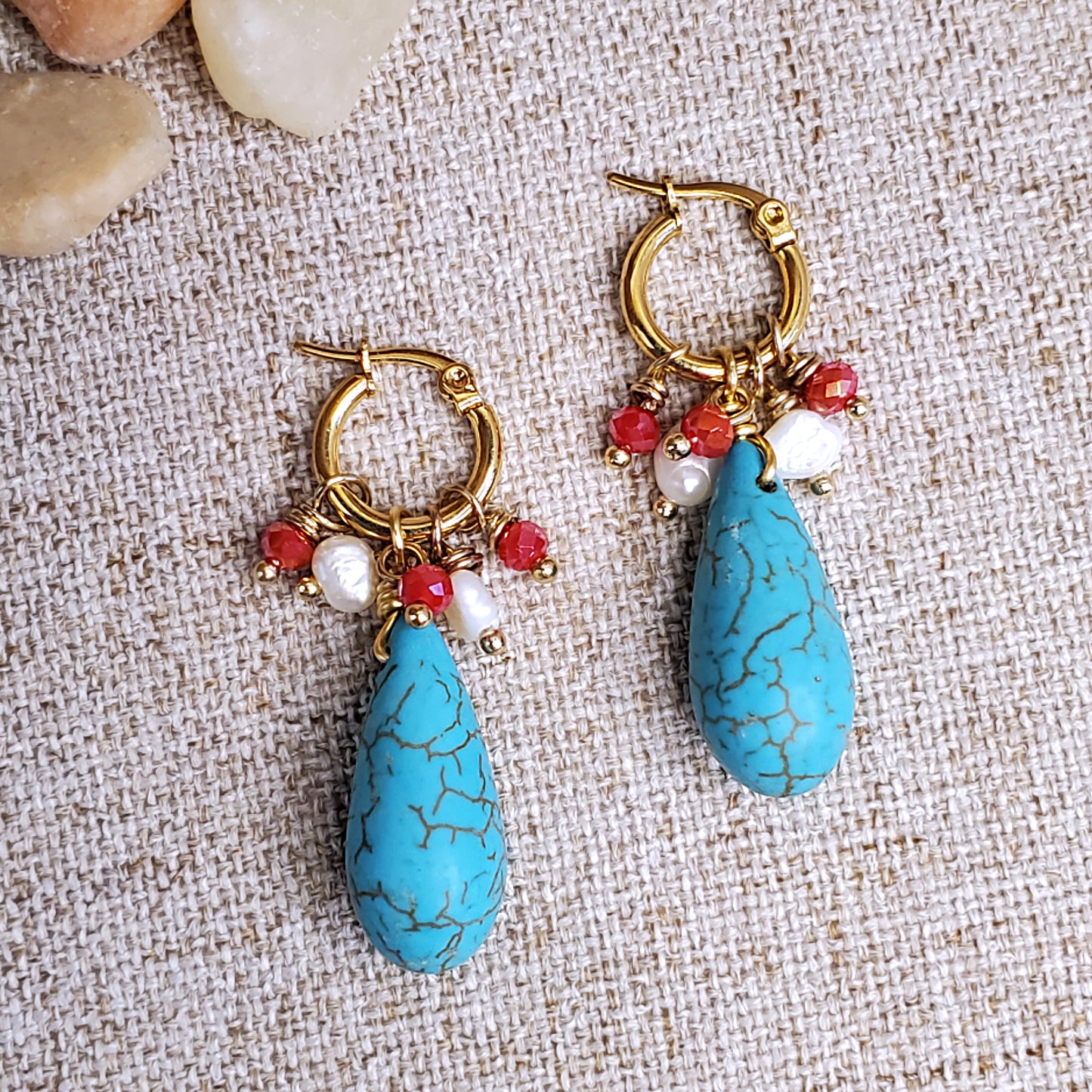 Gold earring hoops with red crystals, fresh water pearls and howlite teardrop bead. 